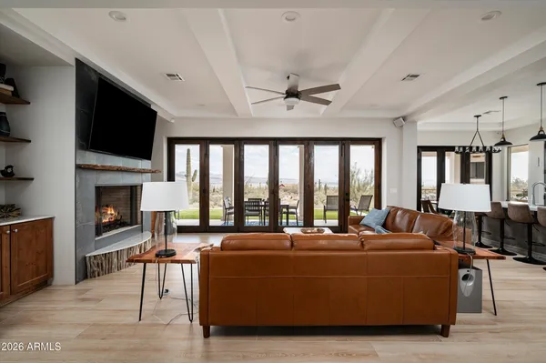 a living room with furniture floor to ceiling window hardwood floor and a flat screen tv