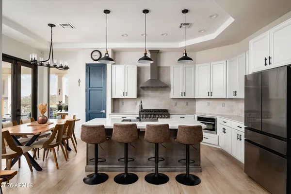 a kitchen with stainless steel appliances granite countertop a sink a stove and chairs