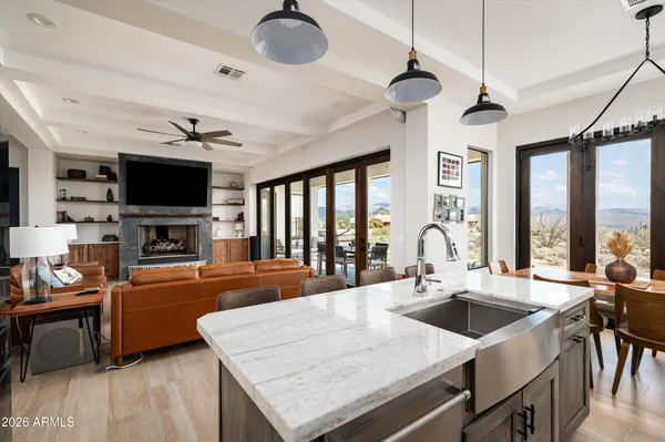 a kitchen with a stove a sink dishwasher a dining table and chairs with wooden floor
