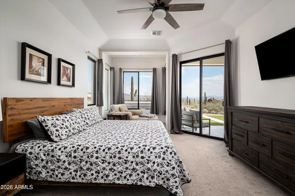 a bedroom with a large bed and a flat tv screen