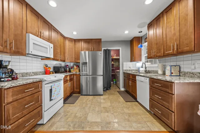 a kitchen with stainless steel appliances granite countertop a refrigerator sink and stove