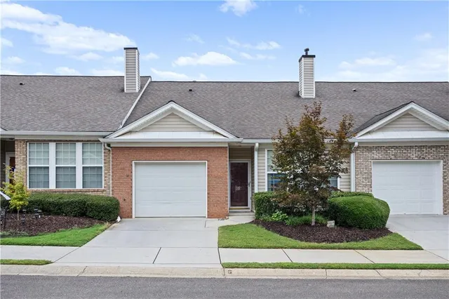 a front view of a house with a garden and plants