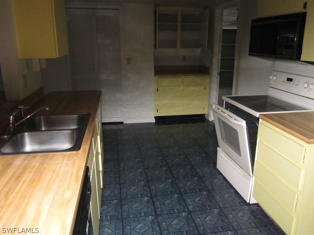 338 Delaware Road Lehigh Acres, FL 33936 - Photo 4 of 11 a kitchen with a sink and a stove top oven