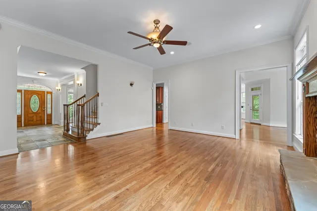 a view of a livingroom with wooden floor and a ceiling fan