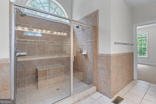 a bathroom with a glass shower door and a window