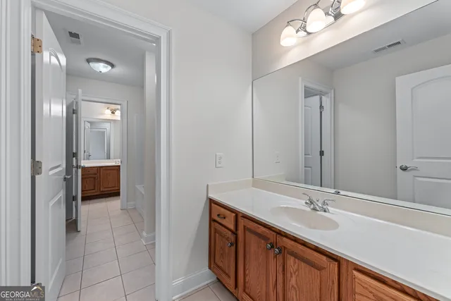 a en suite bathroom with a double vanity sink and a mirror