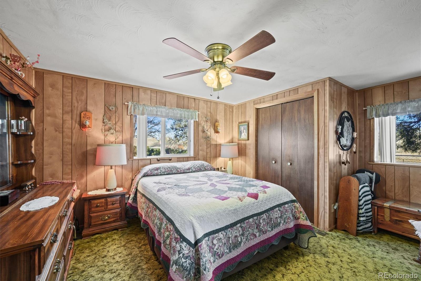 577 Main Street Elizabeth, CO 80107 - Photo 19 of 50 a bedroom with a bed and a chandelier