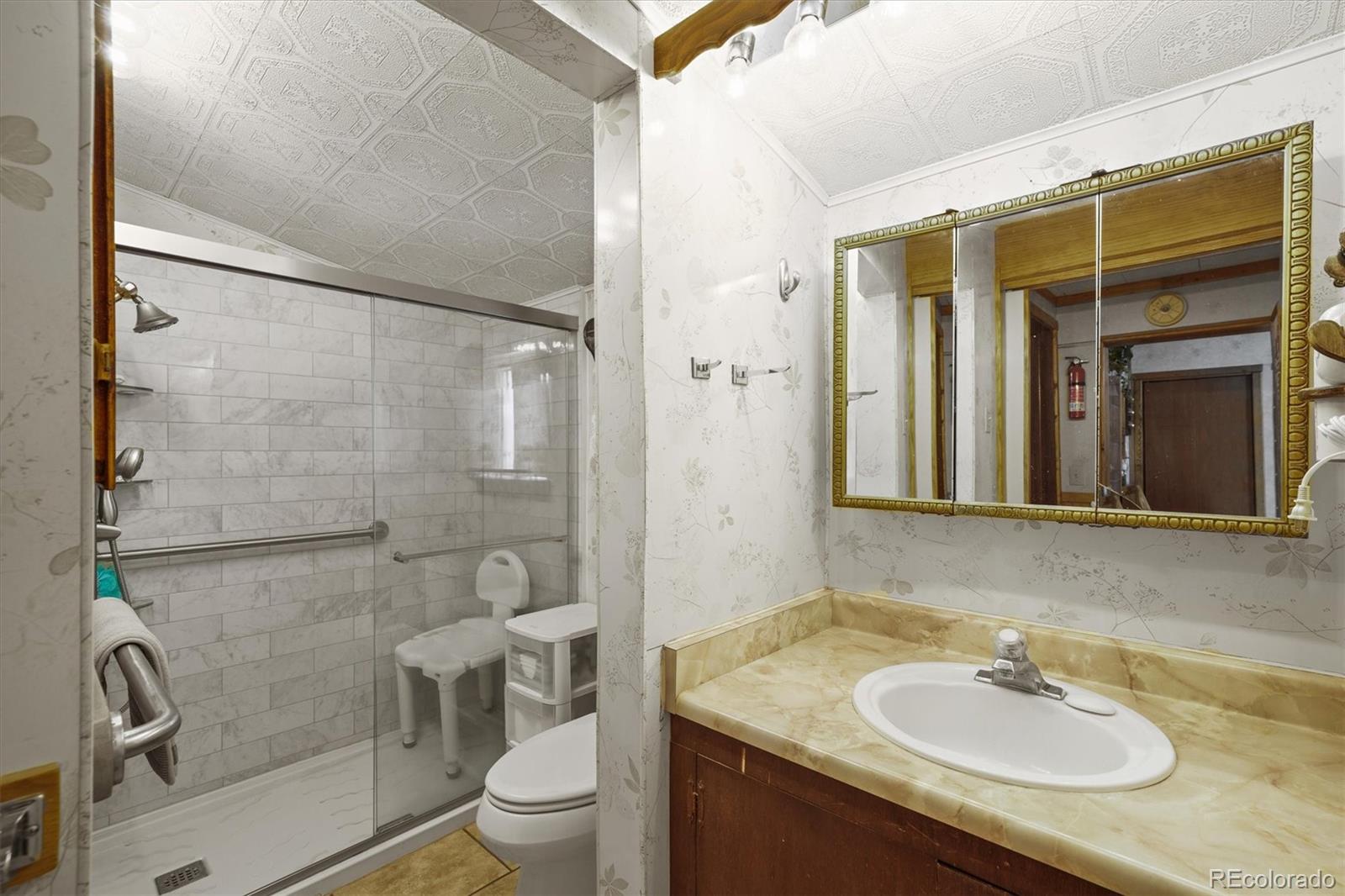 577 Main Street Elizabeth, CO 80107 - Photo 22 of 50 a bathroom with a granite countertop sink toilet and shower