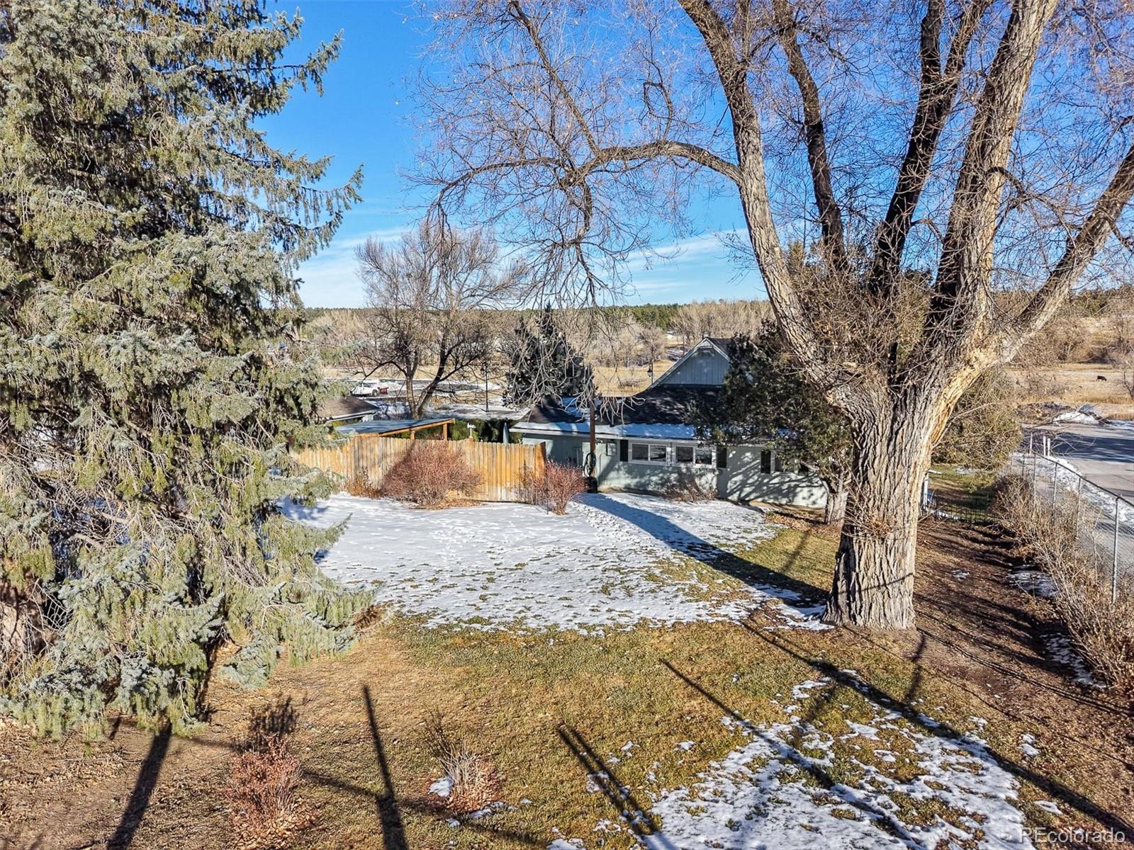 577 Main Street Elizabeth, CO 80107 - Photo 31 of 50 a view of a backyard with wooden fence and a bench