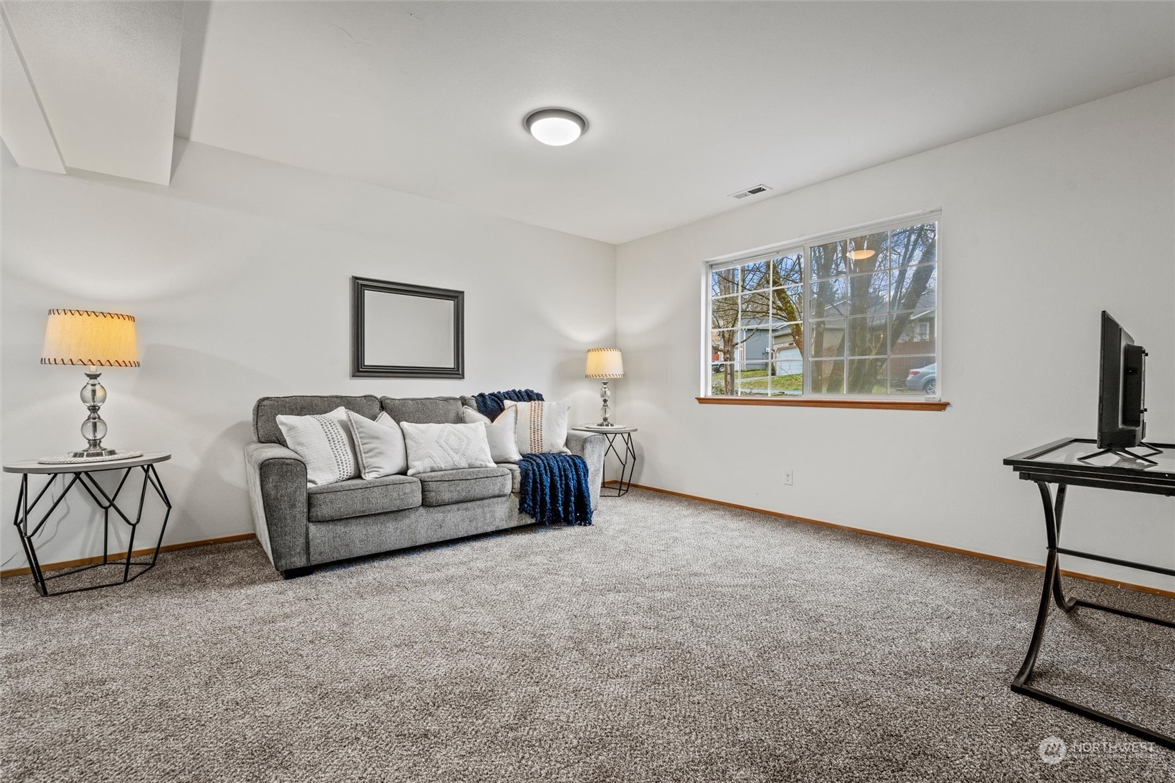 4574 Knute Anderson Road Northwest Silverdale, WA 98383 - Photo 21 of 39 a spacious bedroom with a bed a couch and painting on the wall