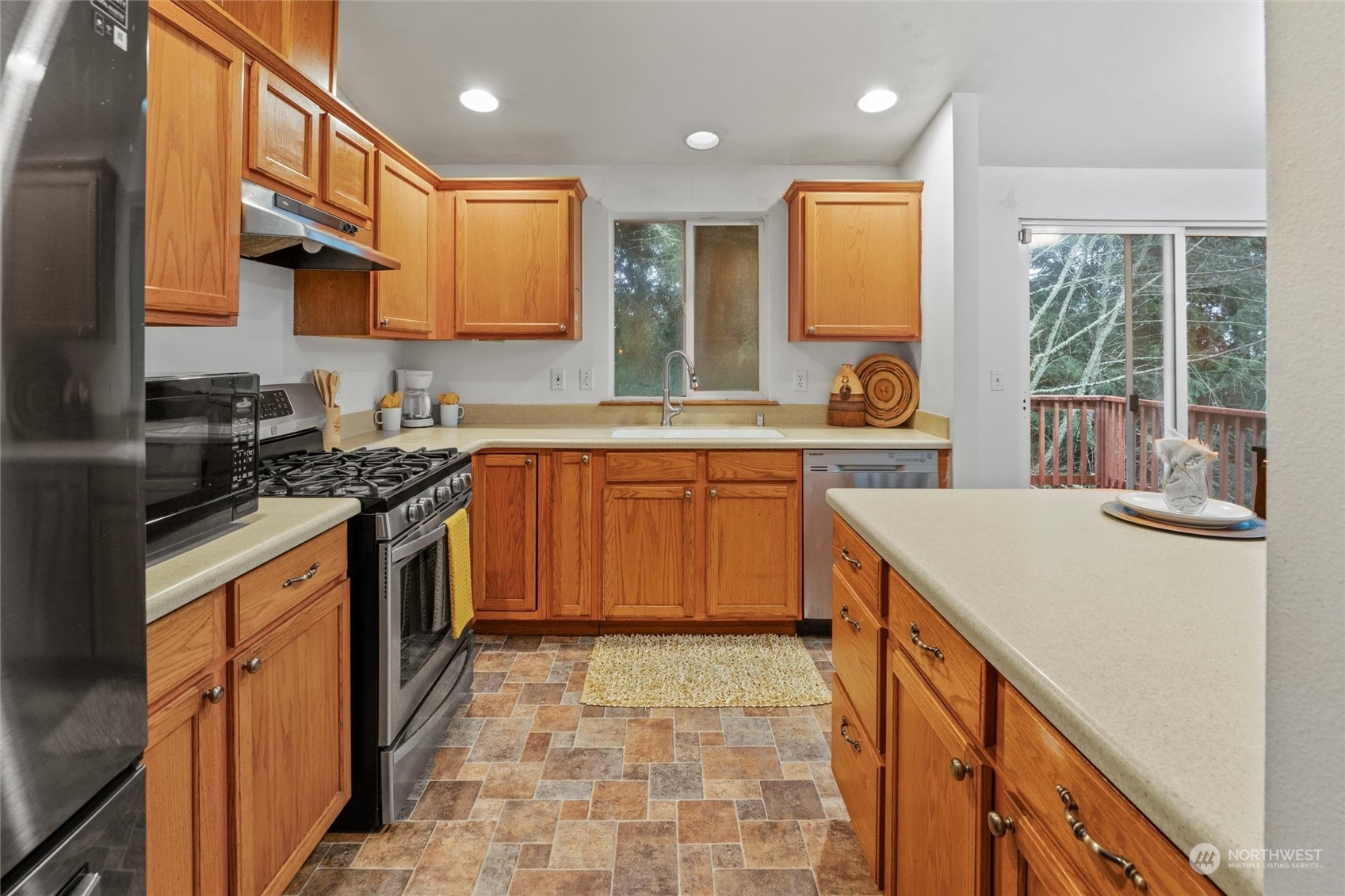 4574 Knute Anderson Road Northwest Silverdale, WA 98383 - Photo 30 of 39 a kitchen with a sink stove and cabinets