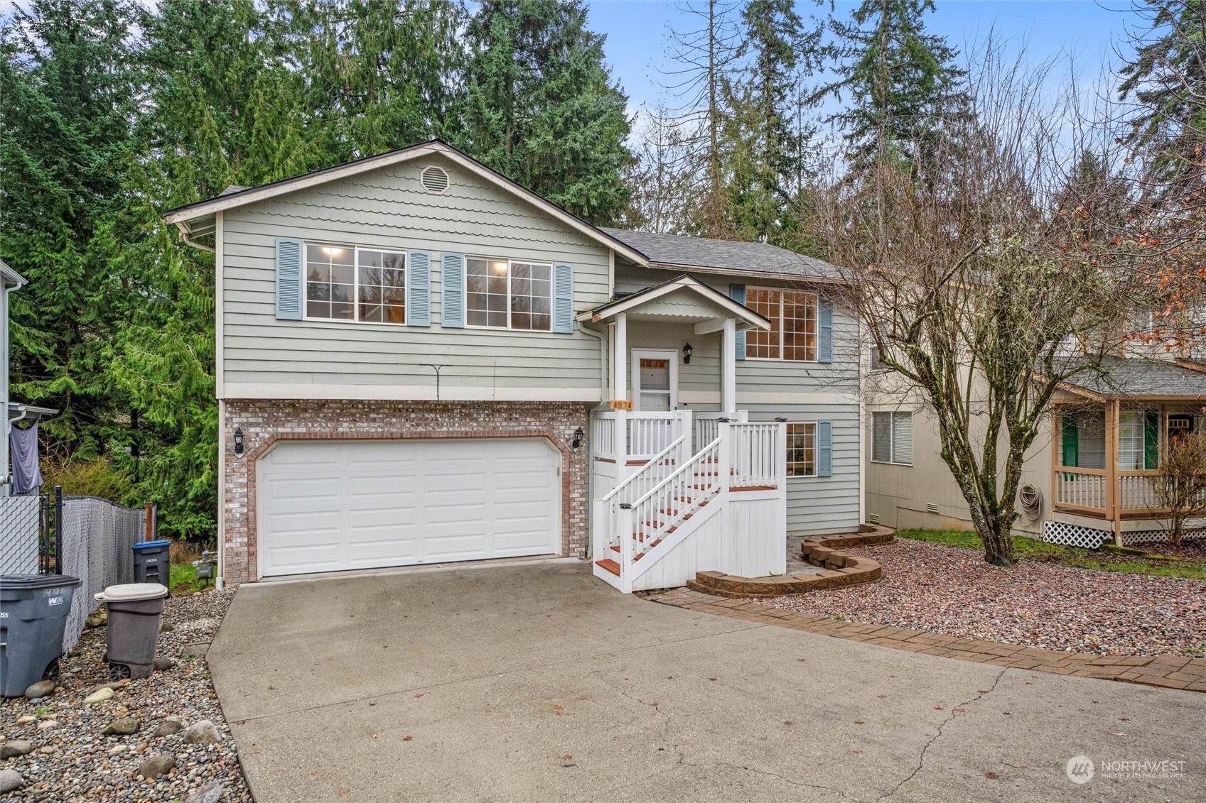 4574 Knute Anderson Road Northwest Silverdale, WA 98383 - Photo 3 of 39 a front view of a house with a yard and garage