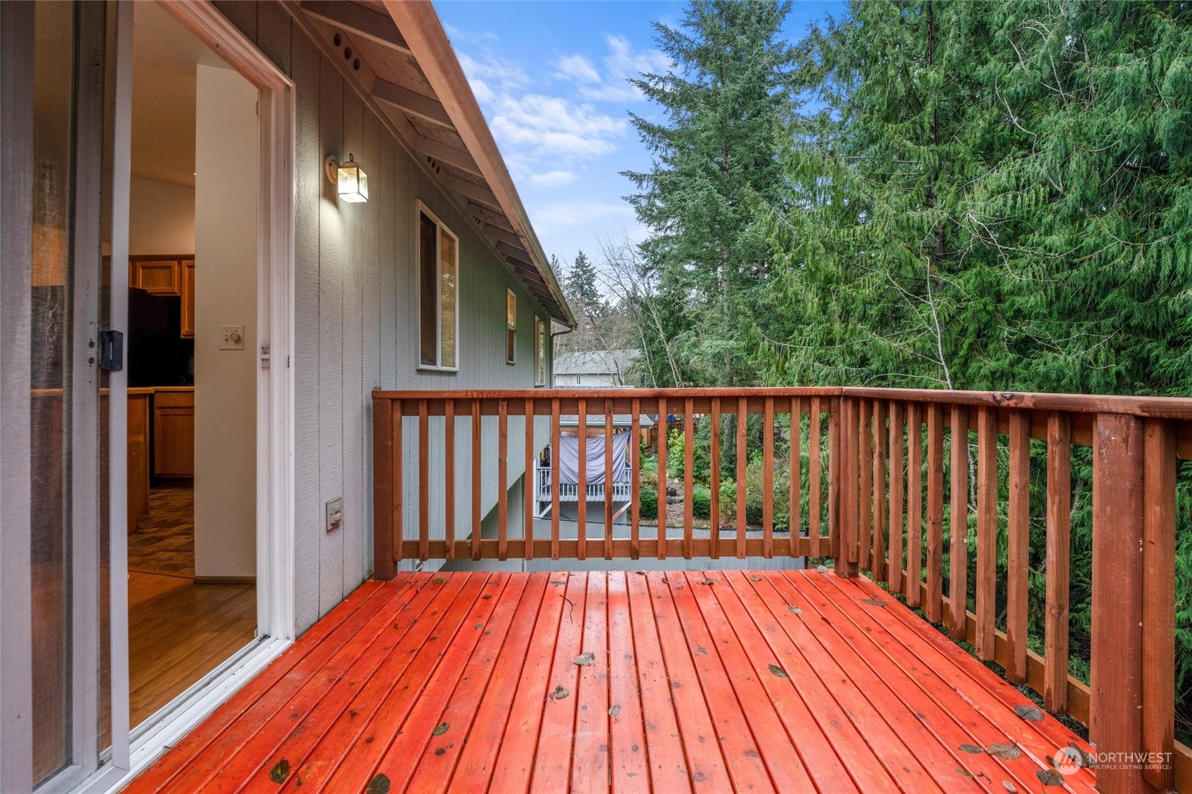4574 Knute Anderson Road Northwest Silverdale, WA 98383 - Photo 35 of 39 a balcony with wooden floor and trees in the back