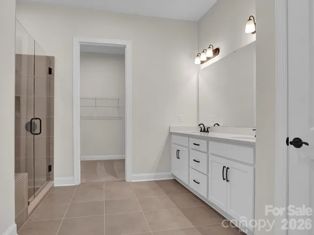 a spacious bathroom with a double vanity sink a mirror and shower