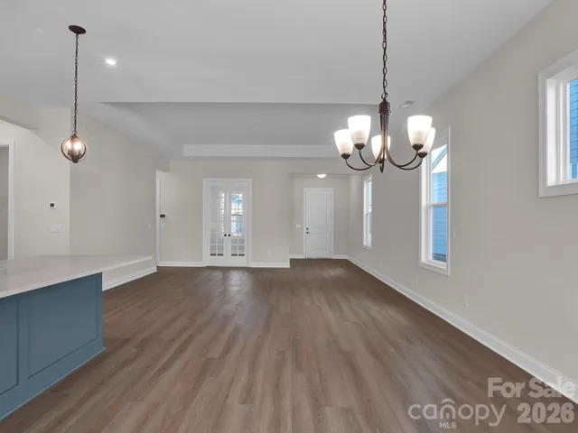 a view of a room with wooden floor and chandelier