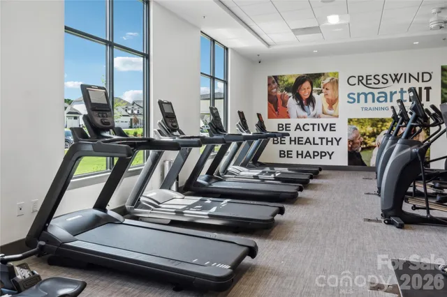 a living room with furniture pool table and large windows