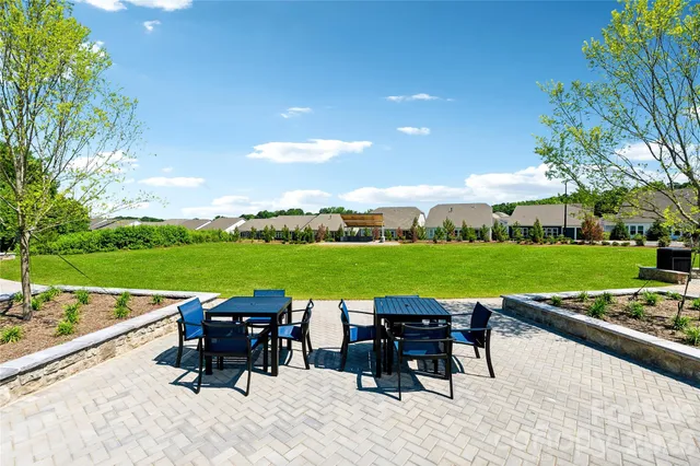 a view of a house with a big yard and sitting area