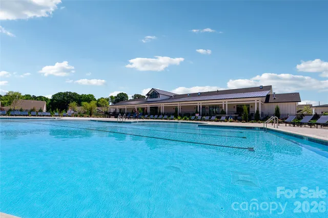 a swimming pool with outdoor seating and barbeque oven