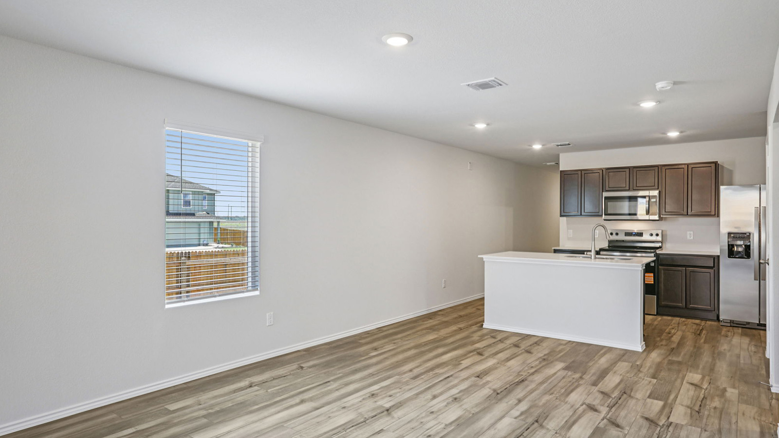 156 Wyatt Way Jarrell, TX 76537 - Photo 8 of 30 Open-concept living area with wood-finish flooring, recessed lighting, and a white kitchen island