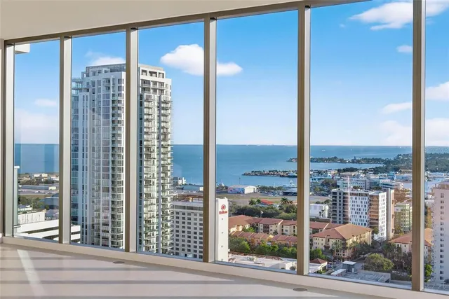 a view of an empty room with wooden floor and a floor to ceiling window