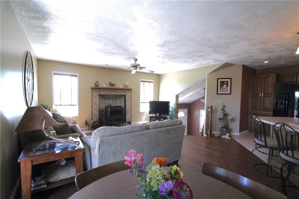 109 Ragan Road Prospect, PA 16052 - Photo 3 of 24 Pristine laminate floors and wood burning stove warm up the living and dining area.