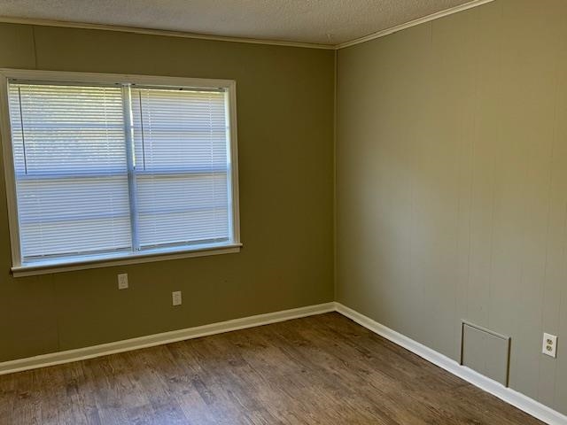 3245 Sinclair Street Memphis, TN 38127 - Photo 11 of 28 Spare room with a textured ceiling, hardwood / wood-style floors, and crown molding