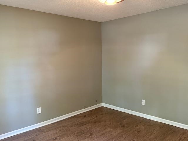 3245 Sinclair Street Memphis, TN 38127 - Photo 10 of 28 Unfurnished room featuring a textured ceiling and dark hardwood / wood-style floors