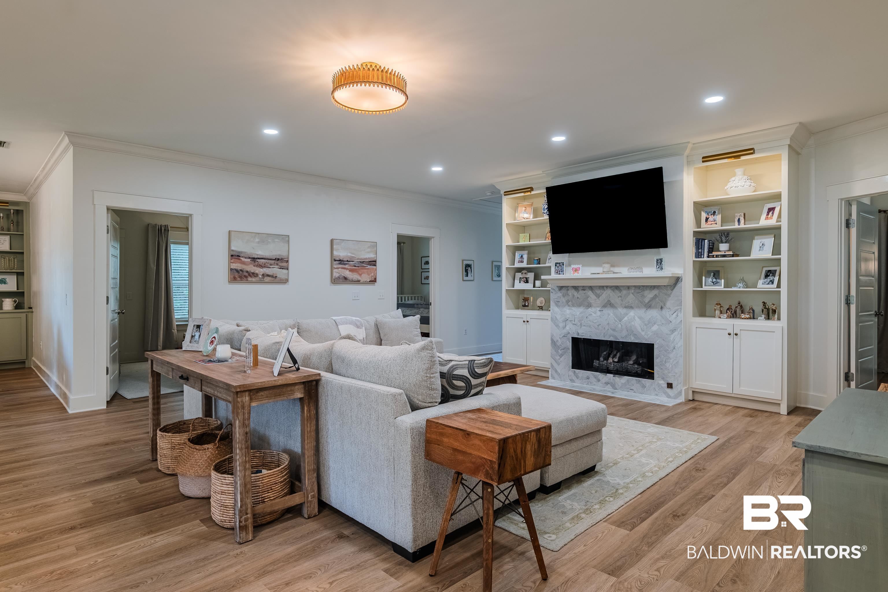 19121 Boothe Road Fairhope, AL 36532 - Photo 13 of 41 Living room with built in features, ornamental molding, light wood-style floors, recessed lighting, and a tile fireplace