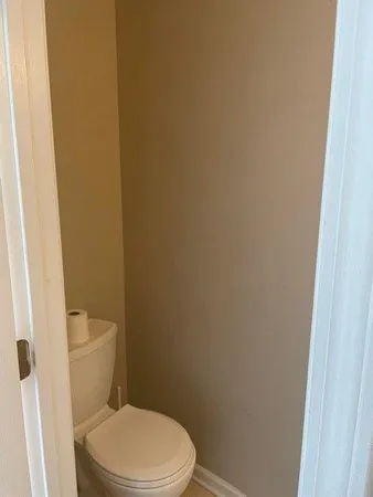 a white toilet sitting next to a shower