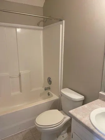 a white toilet and tub sitting next to a bathroom sink