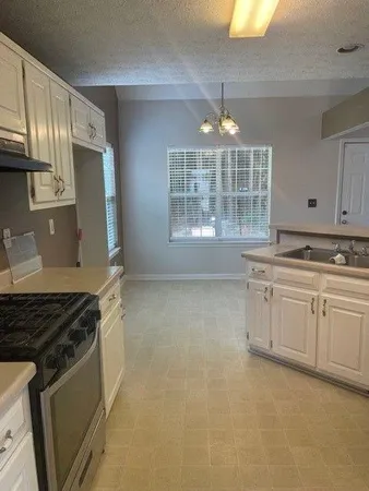 a kitchen with granite countertop a stove and a sink