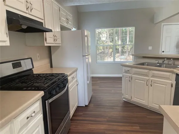 a kitchen with cabinets appliances a sink and a window