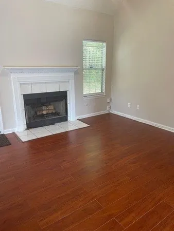 an empty room with windows and fireplace