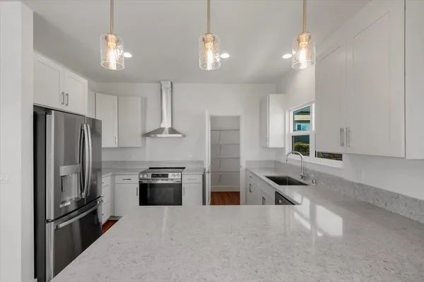 a kitchen with a stove top oven and refrigerator