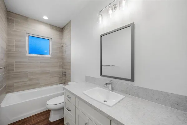 an empty room with windows and ceiling fan