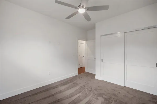 an empty room with closet and windows