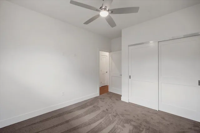an empty room with closet and windows