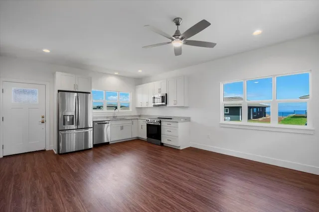 a kitchen with granite countertop a stove a sink and wooden floor