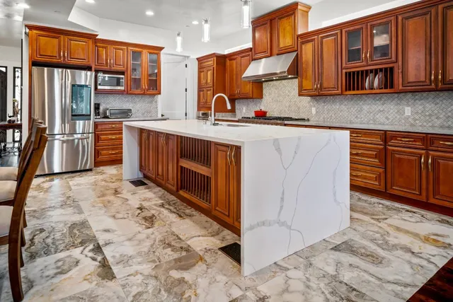 a kitchen with stainless steel appliances granite countertop a stove a sink and a microwave