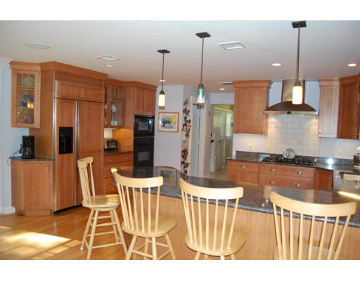 6 Brookwood Road Lexington, MA 02420 - Photo 11 of 27 a kitchen with stainless steel appliances kitchen island granite countertop a refrigerator a stove a kitchen island with a dining table and chairs