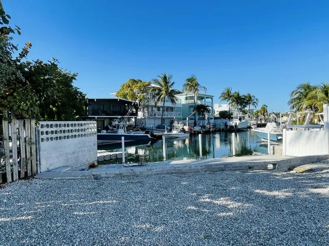 a view of ocean with boats and trees in the background