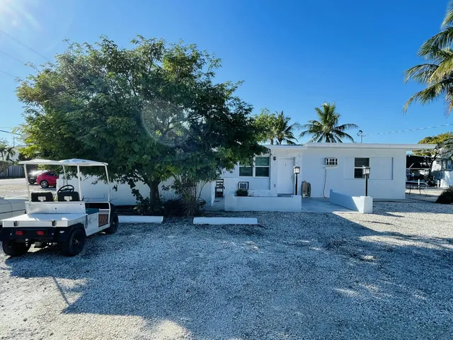 a view of a house with truck parked and a car parked in it