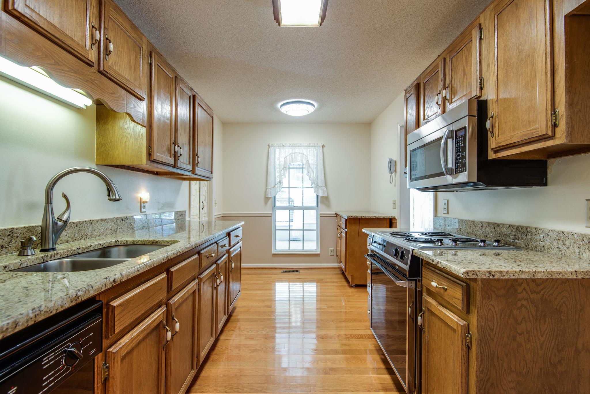 1444 Hunters Branch Road Antioch, TN 37013 - Photo 13 of 27 Granite countertops in the kitchen and beautiful wood floors. The counter on the far end by the window is actually an island on wheels with a matching granite top. Take it to any area you desire!