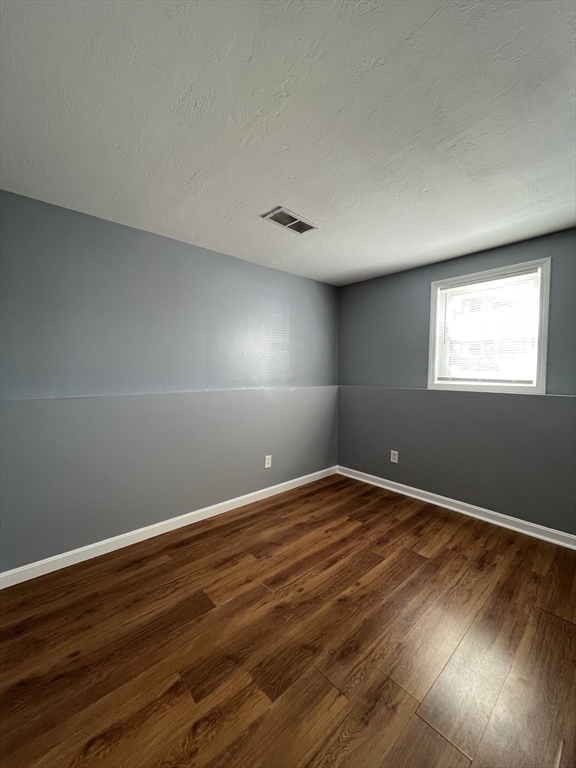 120 15th Street, Unit 4 Fall River, MA 02723 - Photo 6 of 8 a view of an empty room with wooden floor and a window