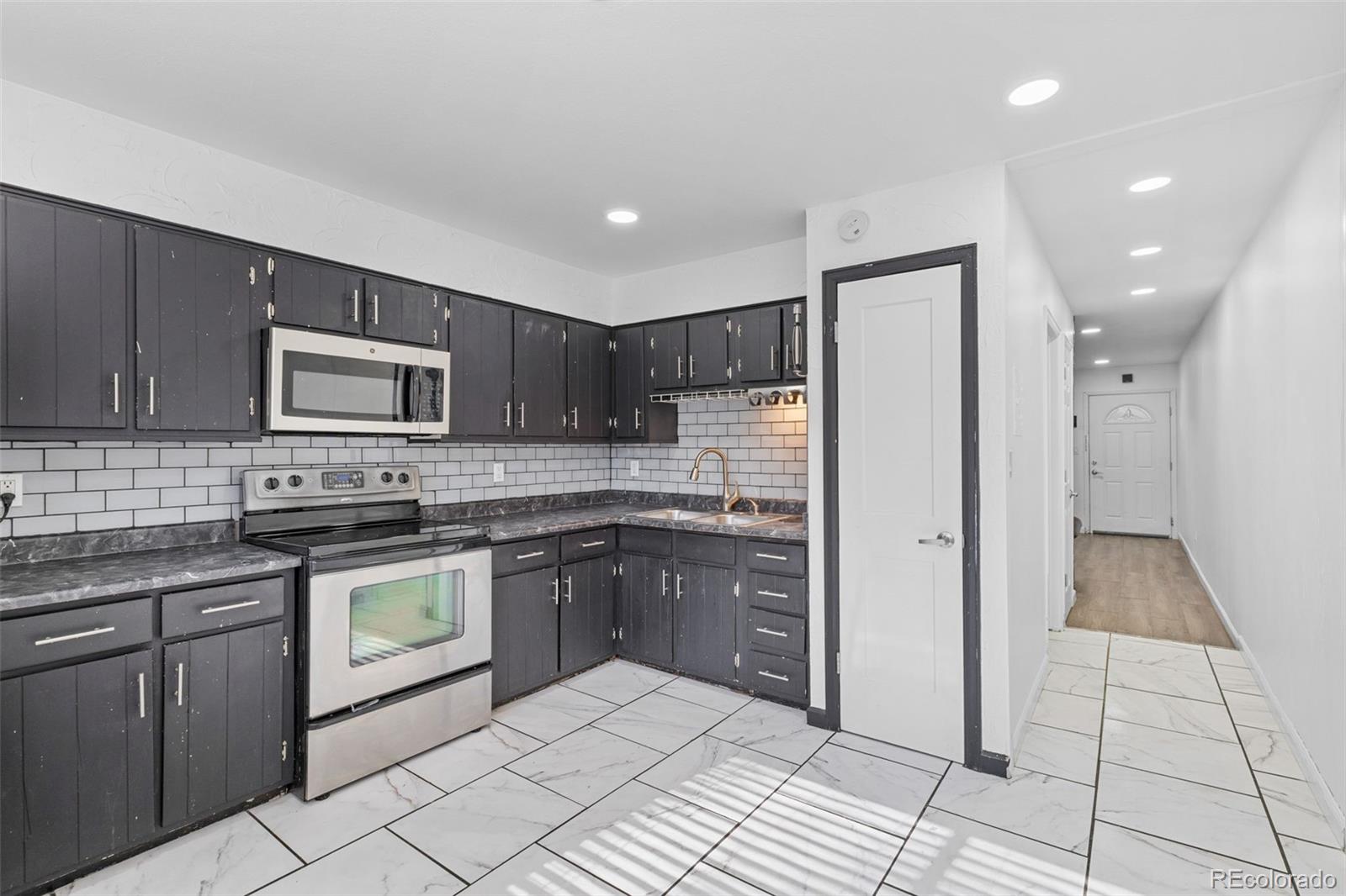 1630 Chester Street Aurora, CO 80010 - Photo 12 of 31 a kitchen with stainless steel appliances granite countertop a refrigerator and a stove top oven