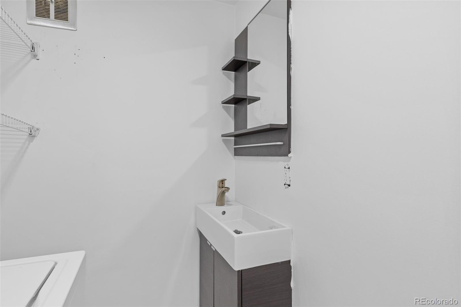 1630 Chester Street Aurora, CO 80010 - Photo 19 of 31 a bathroom with a sink a mirror and window