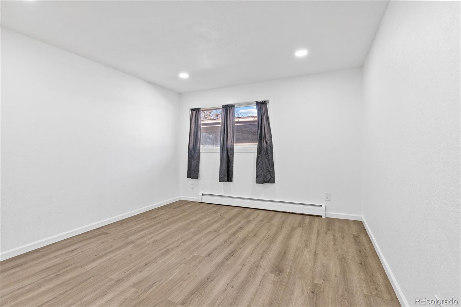 1630 Chester Street Aurora, CO 80010 - Photo 21 of 31 a view of an empty room with wooden floor and fan