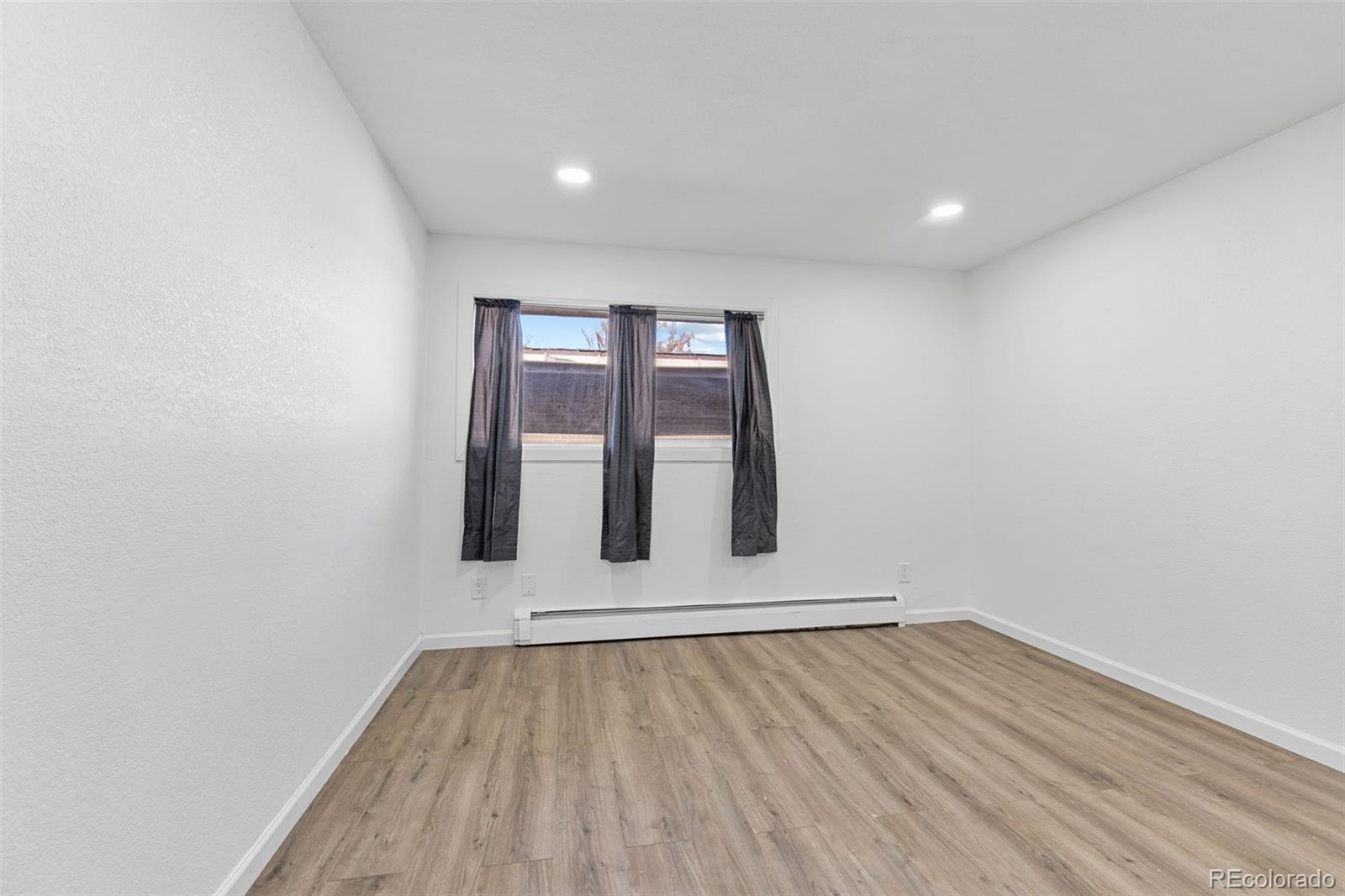 1630 Chester Street Aurora, CO 80010 - Photo 24 of 31 an empty room with wooden floor and window