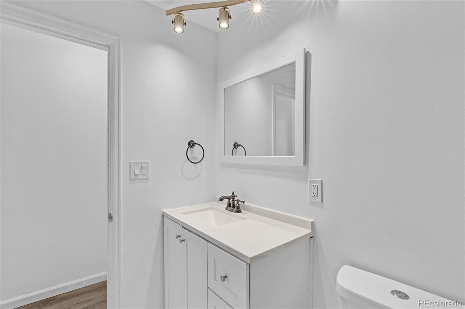 1630 Chester Street Aurora, CO 80010 - Photo 27 of 31 a bathroom with a sink a toilet and a mirror