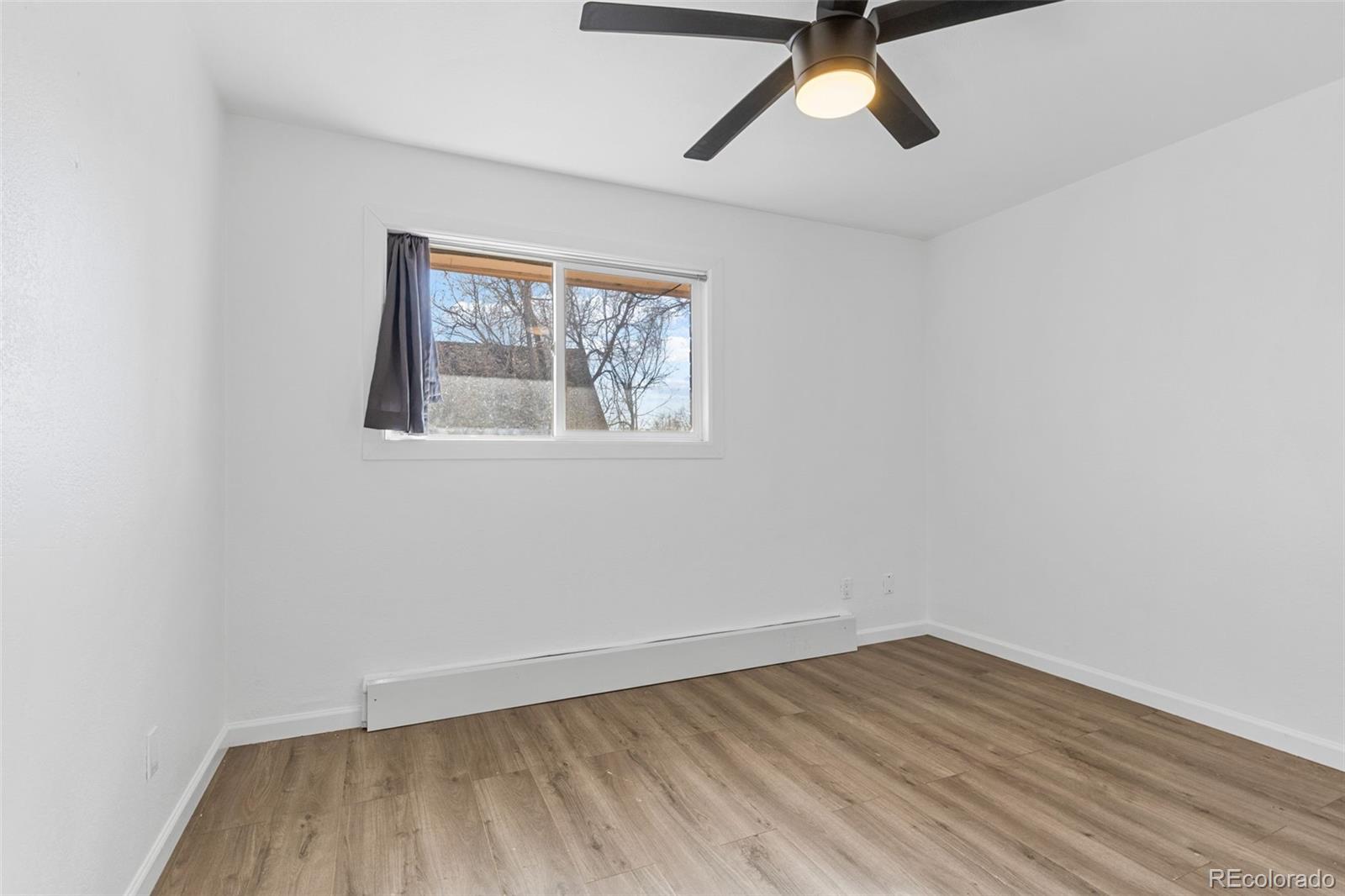 1630 Chester Street Aurora, CO 80010 - Photo 28 of 31 an empty room with a window and a ceiling fan